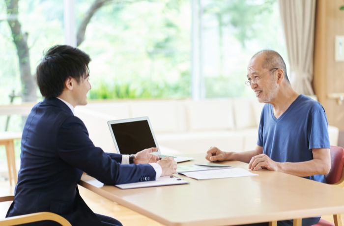 行政書士と遺書の打ち合わせをする男性